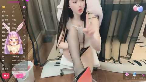 Media: A video of an East Asian woman with long, straight black hair and fair skin, sitting on a white office chair, wearing black stockings and high heels, in an office setting.