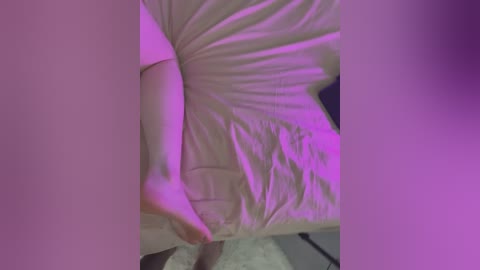 Media: Video of a person with fair skin, wearing a white t-shirt, partially unbuttoned, revealing a white bra. The image is illuminated by purple light, creating a surreal, intimate atmosphere.