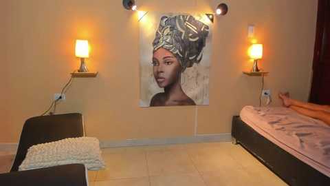 Media: Video of a cozy, dimly lit bedroom with beige walls, featuring a large framed portrait of a dark-skinned woman in traditional African attire, two bedside lamps, a white quilted blanket, and a partially visible person lying on a bed.