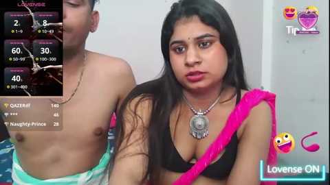 Media: A video shows a young South Asian woman with long black hair, wearing a pink sari, seated next to a shirtless young man, both indoors. The image overlays a Lovense ON app interface.