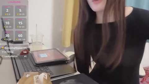 Media: A video of a woman with long brown hair in a black top, using a tablet on a desk, with a live streaming overlay showing viewers and a chat.