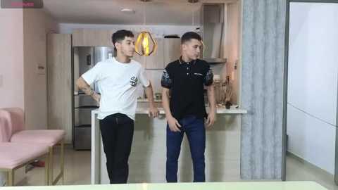 Media: Video of two Asian men in a modern kitchen; one in a white T-shirt and black pants, the other in a black polo and blue jeans.