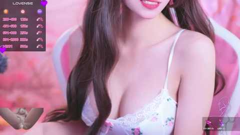 Media: A video of a smiling Asian woman with long, straight brown hair, wearing a white lace bra with floral patterns. Background features a pink chair and blurred, soft-focus lighting. Text overlay includes a social media profile and engagement metrics.