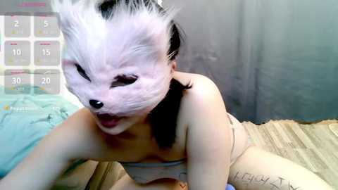 Media: Video of an Asian woman in a panda mask and beige top, lying on a bed with a calendar overlay, revealing a date of 20/1.