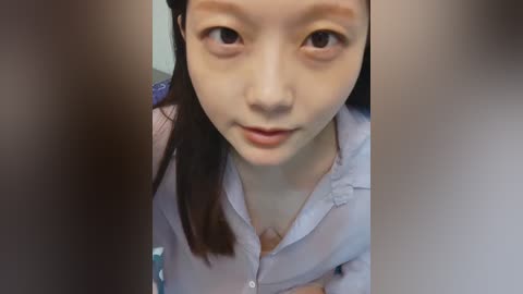 Media: Video of an Asian woman with light skin, brown eyes, and long brown hair. She wears a light purple shirt. Background is blurry.