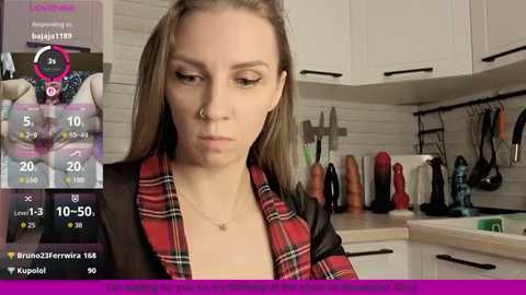 A video of a woman in a red plaid shirt, standing in a modern kitchen with a variety of sex toys on the counter, overlaid with a virtual reality app.