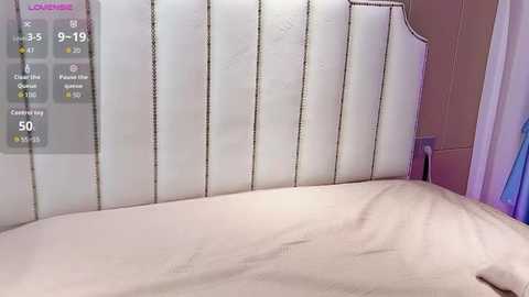 Video of a hospital bed with white sheets and a padded headboard, featuring a digital screen displaying vital signs and patient data.