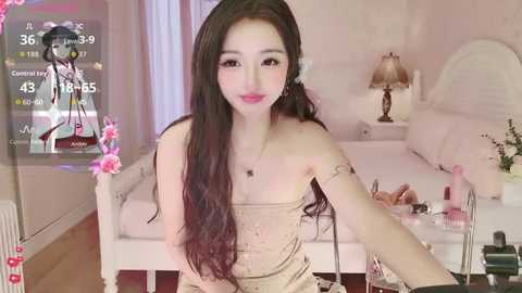 A video of an East Asian woman with long black hair, wearing a beige lace dress, sitting on a bed in a pastel-colored bedroom, with a TV displaying a weather forecast.