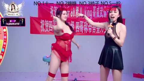 Video of two women in red and black lingerie, performing on stage. The background features red banners with Chinese text.
