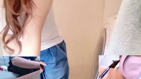 A video of a fair-skinned woman with long, wavy brown hair, wearing a white tank top and blue jeans, leaning over a washing machine. The background is a plain, beige wall.