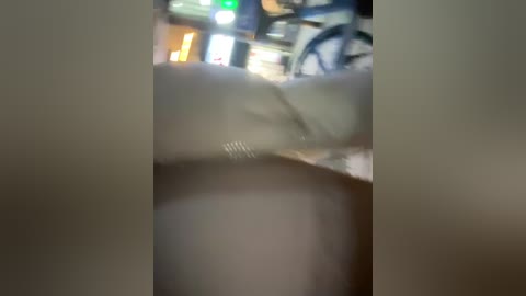 Video of a blurred, close-up scene showing a white surface with faint vertical lines and a blurred background of a possibly urban setting with neon lights.