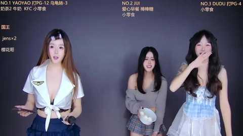 Video of three East Asian women in cosplay, each with different hairstyles and outfits, against a plain background.