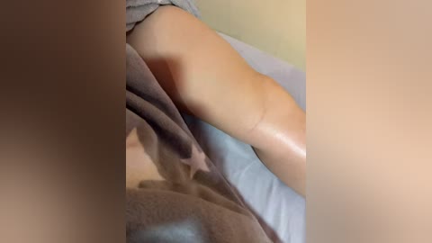 A close-up video of a person lying on their back on a massage table, with their buttocks and lower back exposed. The skin tone is light, and a massage therapist's hands are massaging the lower back. The background is blurred, focusing on the massage area.