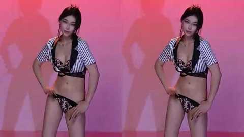 A video of an East Asian woman with a slim build, dark hair, and fair skin, wearing a striped crop top and leopard-print panties, striking a pose against a pink background.