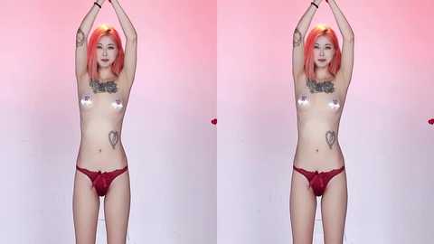 Video of a topless, slim, fair-skinned woman with pink hair, wearing red lace panties, standing against a pink gradient background, arms raised.