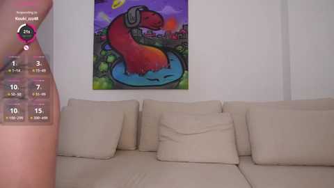 Video of a modern living room with a beige sectional sofa, vibrant abstract painting of a red snake in a blue pond, and a virtual reality headset displaying a snake-themed game.