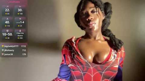 Video of a dark-skinned woman with braided hair, wearing a revealing red Spider-Man costume, revealing her large breasts. Background is blurred, showing a live stream overlay with stats and comments.
