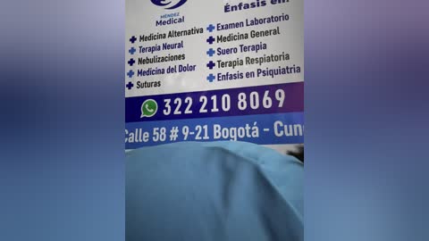 Video of a medical clinic's sign with a blue background, listing services like medical alternatives, emergency room, and labs, with a phone number and WhatsApp option.