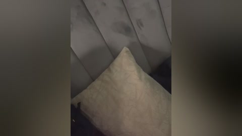 A dimly lit video showing a close-up of a person's leg, with a textured beige sock and a dark, possibly wet, surface beneath. The image is slightly blurred and grainy.