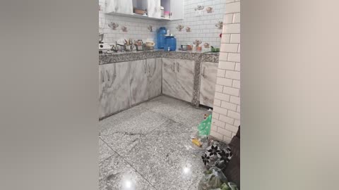 Video of a small, modern kitchen with white subway tiles, granite countertops, stainless steel appliances, and a black and white tiled floor. The image is a clear, well-lit view of the kitchen's interior.