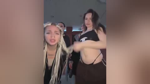 Video of a lively nightclub scene featuring three women: one with dreadlocks, one in a black sports bra, and one in a black crop top, dancing energetically.
