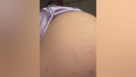 Video of a close-up view of a woman's lower back and buttocks, wearing light purple panties. The image is blurry and grainy, with a muted color palette.