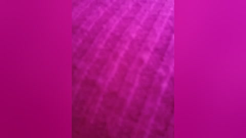 Video of a vibrant magenta wall with a subtle, textured pattern. The wall's surface is smooth with a slight sheen, creating a modern, minimalist aesthetic. The image has a sharp focus, capturing the entire wall's depth and color.