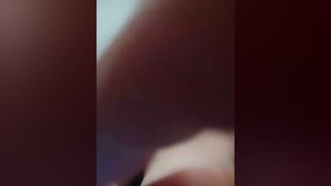 A blurred video showing a close-up of a person's lower body, with indistinct skin tones and indeterminate clothing. The background is dark, making the subject hard to discern.