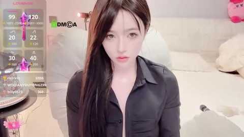 Video of a young Asian woman with long black hair, fair skin, wearing a black shirt, sitting in a modern bedroom. The room features a white bed, pink plush toys, and a digital thermometer.