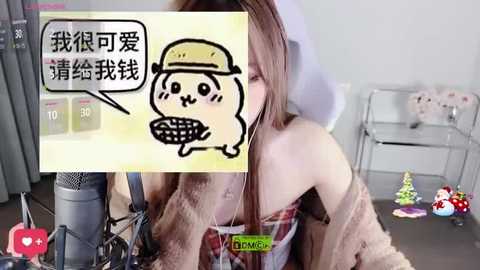 A video of a woman with light skin and shoulder-length brown hair, wearing a beige sweater, recording a video with a microphone. Background features a white wall and colorful holiday decorations.