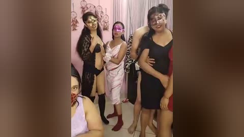 Video of five women in a dimly lit room, wearing black and white lingerie, with one wearing a pink mask.