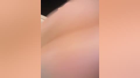 A close-up video of a person's bare buttocks and thighs, showing smooth, light peach-toned skin. The image is slightly blurred, making it difficult to discern specific details or textures.