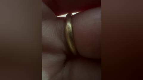 Close-up video of two interlocked hands, one wearing a golden ring, the other with a darker skin tone, creating a warm, intimate scene.