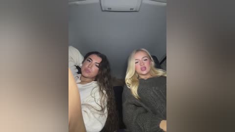 Media: Video of two young women, one with long dark hair, the other with blonde, in a car, making silly faces, wearing casual clothes.