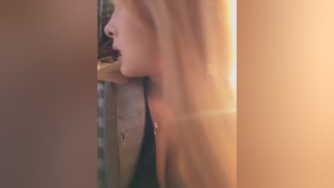 A close-up video of a fair-skinned woman with long, blonde hair eating a sandwich, partially obscured by a vertical frame.