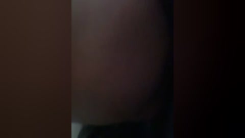 This is a blurry, dimly lit video featuring a person's face in the center. The background is dark, making the subject's features indistinct. The image suggests a moody, possibly intimate setting.