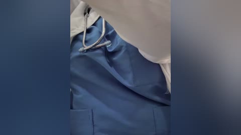 A video of a hospital setting showing a white doctor's coat and blue scrubs with a stethoscope draped over the shoulder, emphasizing medical attire and professionalism.