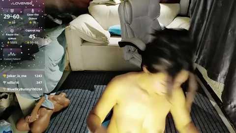 Video of a man and woman in a bedroom, both topless, engaged in sexual activity. The man, shirtless, has his hand on his face, and the woman, lying on a bed, is partially clothed.