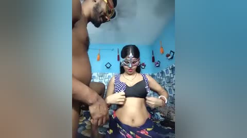 Media: Video of a muscular Black man and a petite Latina woman in a bedroom; she wears a Wonder Woman costume, and they appear to be interacting.