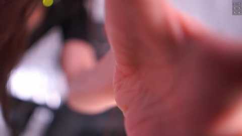 Video of a close-up of a person's arm, with visible skin texture and slight blurriness, likely taken indoors, with a focus on the hand and fingers.