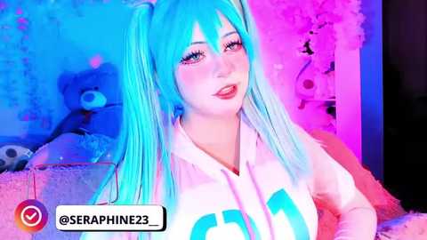 A vibrant video of a young woman with long turquoise hair, wearing a white hoodie with \"SERO\" on the chest, standing in a pink and blue-lit room.