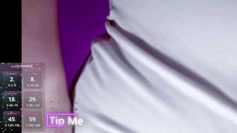 A video of a white, wrinkled person's leg with a visible vein and a purple background. The image includes a digital calendar display with a \"Tip Me\" button.