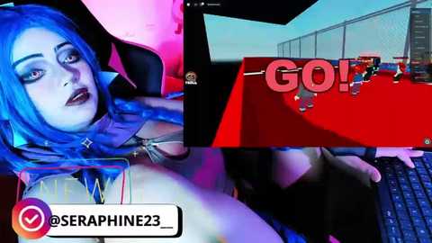 Video of a blue-haired woman with dark makeup, lounging on a gaming chair. She's in a dimly lit room with a red desk and gaming setup. \"GO!\" text displayed.