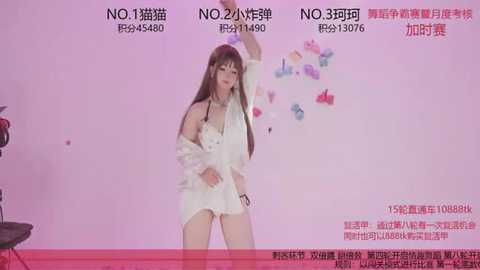 Video of an Asian woman with long brown hair, wearing a white lace dress, standing on a red stage, against a pink background, with Chinese text and butterfly decorations.