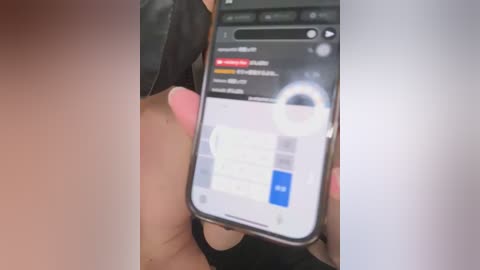 A video shows a person holding a smartphone with a white background and a blue chat icon. The phone displays a message with a red notification bubble. The person's hand is partially visible, wearing a black watch.