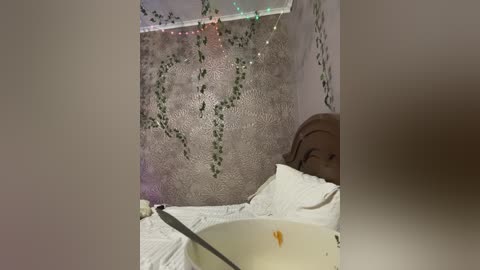 Video of a child's face peering over a white bowl, with a knife in the bowl and a messy, cluttered room in the background.