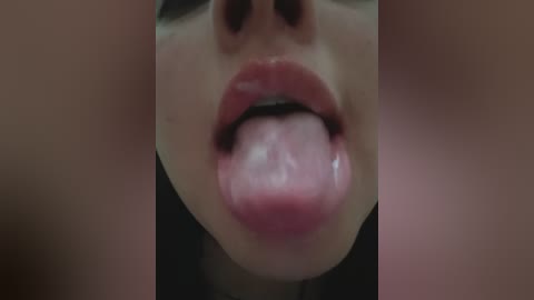 Video of a close-up of a person's mouth, with slightly parted lips revealing a tongue. The background is blurred, showing two out-of-focus faces on either side.