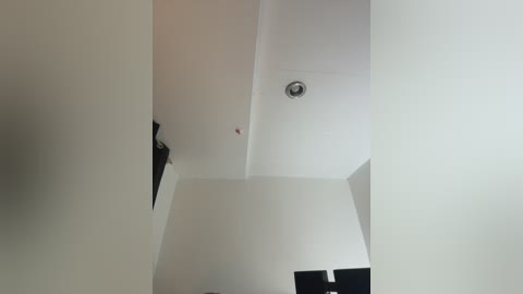 Video of a modern, minimalist interior with white walls and a recessed ceiling light, showcasing clean lines and an empty, serene space.