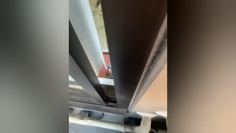 A video of a close-up view of a metal framework with horizontal and vertical beams, showing a detailed, industrial structure. The metal surfaces are smooth and slightly reflective, with shadows accentuating the depth and form.