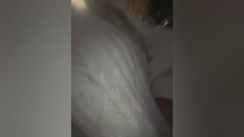 Video of a blurred, possibly female figure in a white shirt, partially obscured by a dark background, creating a sense of motion and uncertainty.